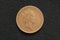 Queen Elizabeth II on obverse of the Great Britain one penny coin of 1996, isolated on a grey cloth background