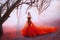 Queen in long red dress with magnificent lush train, woman walks alone through scarlet autumn forest, gold crown and