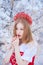 Queen in a red crown among the winter forest. Lovely girl in a