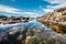 Queen`s Bath on Kauai, Hawaii island. Ocean pond in rocks with sky reflection