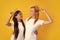 Queens in tiara. Funny family on a yellow background. Mother and her daughter girl with crown. Two princess.