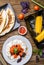 Quesadilla, salad with cottage cheese and tomatoes, two corn on wood table.