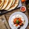 Quesadilla, salad with cottage cheese and tomatoes, two corn on wood table.