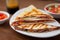 Quesadillas triangles with beef meat and vegetables on plate on blurred background