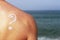 Question mark drawn by sunscreen on male back, skin protection concept