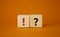 Question mark and exclamation mark symbol. Question mark and exclamation mark on wooden cubes. Beautiful orange background.