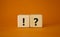 Question mark and exclamation mark symbol. Question mark and exclamation mark on wooden cubes. Beautiful orange background.