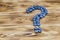 Question mark made of fresh ripe natural blueberries on a brushed wooden background. Healthy diet question concept