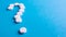 Question mark made of many white pills on a blue background. Healthcare concept. Creative medicine for health medical problem,