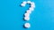 Question mark made of many white pills on a blue background. Healthcare concept. Creative medicine for health medical problem,