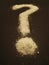 A question mark made from salt on a black background.