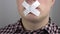 A question mark on a man\'s lips  a man with a sticky tape sealed his mouth  a man covered his mouth with a leuco plaster.