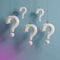 Question marks hanging on gradient background seeking answers concept