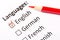 Questionnaire concept. Languages with English, German, French, Spanish checkboxes with red pencil. Close up image with focus on th