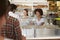 A queue of customers served by two women at a sandwich bar