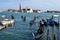 Queue of gondolas moving inside the city with a lot of tourists in Venice.