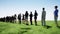 The queue of people on the background of a field of grass