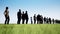 The queue of people on the background of a field of grass