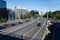 Queued cars waiting at arrival of downtown city on highway with city buildings lining left side and shadow of person on