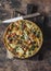 Quiche with kale, chicken, zucchini, sweet pepper, ham, mozzarella cheese on a wooden cutting board, top view. Delicious snack,