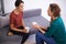 Quick coffee discussion. Shot of two female professionals having a discussion in an informal office setting.