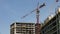 Quick motion of a working construction crane on a background of clear blue sky