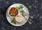 Quick ratatouille and bread on a white plate on a dark background. Delicious healthy vegetarian food.