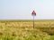 Quicksand danger warning sign in coastal saltmarsh of West Frisian island Schiermonnikoog at low tide of Waddensea, Netherlands