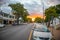 Quiet afternoon in Stellenbosch. People crossing the road, cars driving by, lush green trees and a tranquil sunset in background.