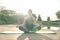 Quiet mind. Relaxed middle aged woman meditating, sitting in Lotus pose while doing yoga on a mat in a green park