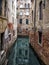 Quiet narrow canal in venice surrounded by picturesque ancient buildings reflected in the water