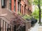 Quiet neighborhood street sidewalk lined with historic brownstone buildings in a Greenwich Village neighborhood in Manhattan New