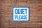 Quiet Please sign on red brick wall