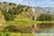 Quiet pond from Chemal River in Chemal district, in the distance mountains covered with conifers, selective focus