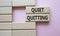 Quiet quitting symbol. Concept word Quiet quitting on wooden blocks. Beautiful pink background. Business and Quiet quitting