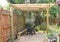 A quiet relaxing and shady area in a back garden under a pergola and magnolia tree