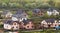 Quiet residential suburban area. Street with new modern comfortable brick cottages with yards and blooming gardens on background