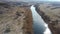 Quiet river in the countryside. From above, an amazing river with calm water located next to a spring forest in nature