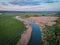 Quiet river flows along the plain. Riversides, overgrown with reeds, green meadows. Beautiful scenery from a bird`s eye view at su