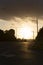 Quiet Road Reflecting Sunlight Off Asphalt With Heavy Rain Cloud Above