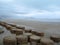 A quiet sandy beach in the morning with a rock formation built to protect against strong waves from the ocean.