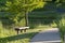 A quiet spot with park benches along a curved walking path next to a pond