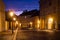 Quiet street of Prague, the capital of Czech Republic. Empty cobblestone road lit by vintage lamps under the colorful sky.