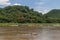 Quiet view of a wooden boat sailing on the Mekong river near Luang Prabang, Laos