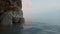 Quiet water and rocks at sunset, against a sky with clouds