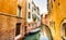 Quiet Yellow Venetian Canal with Boat in Still Water, Venice, Italy