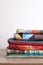 Quilts stacked on wooden table on white wall background