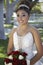 Quinceanera With Flower Bouquet In Lawn