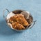 Quinoa crusted chicken in a metal bowl.