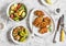 Quinoa crusted chicken, vegetable salad, grill eggplant and pepper - dinner table. On a light background